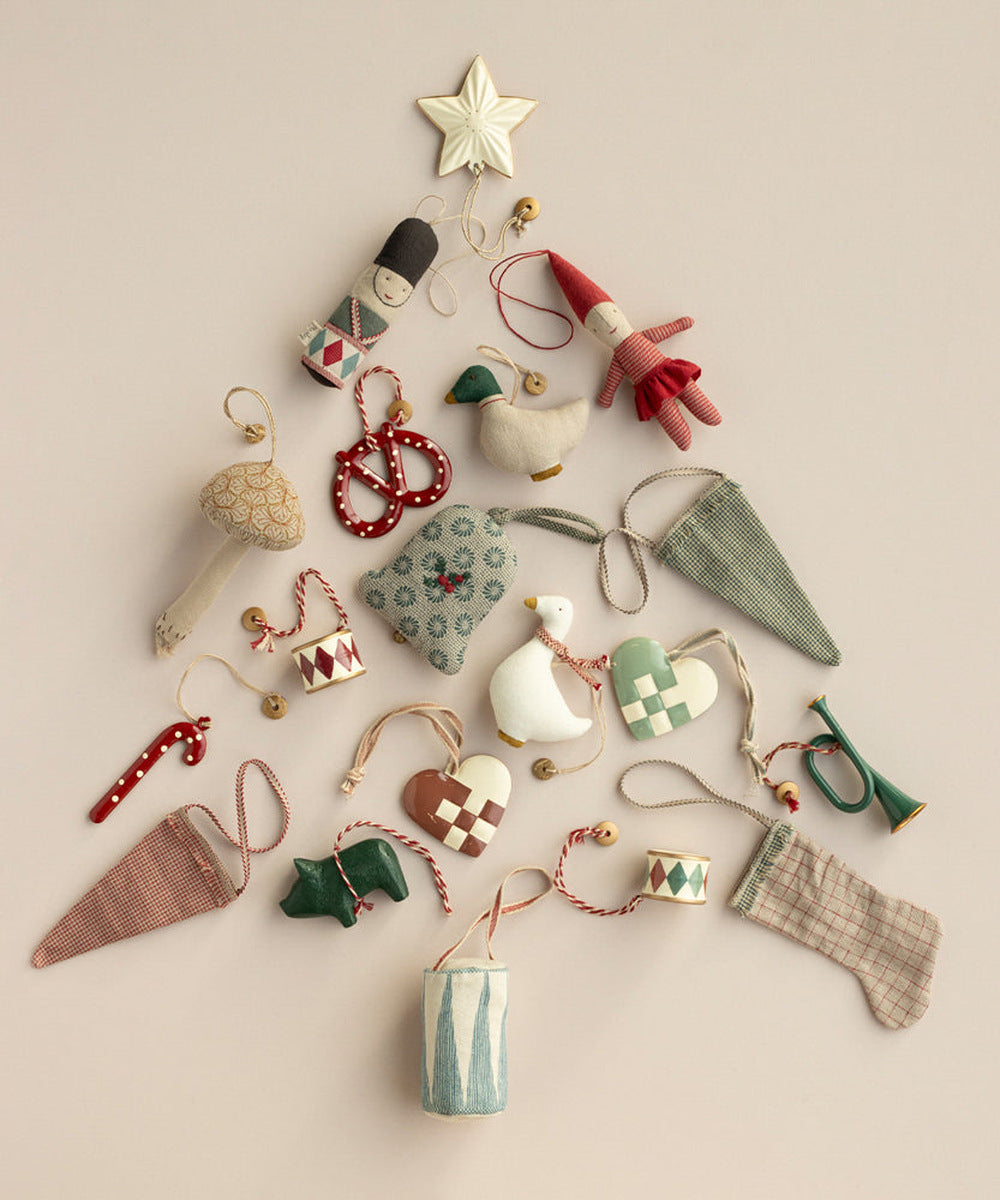 Sucre d’orge Maileg parmi des décorations de Noël disposées en sapin