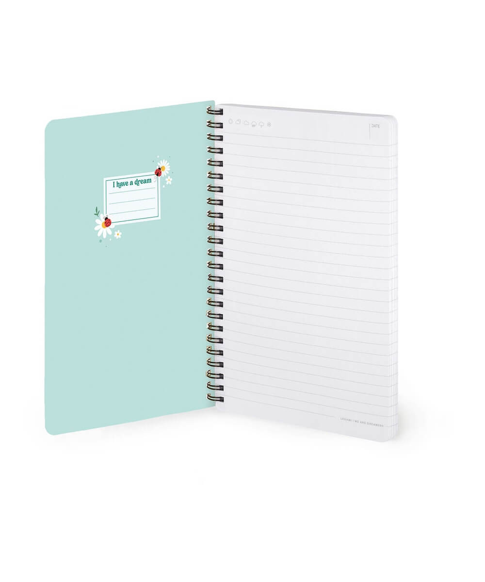Cahier A5 Coccinelle de Legami ouvert sur ses pages lignées et sa couverture intérieure, sur fond blanc