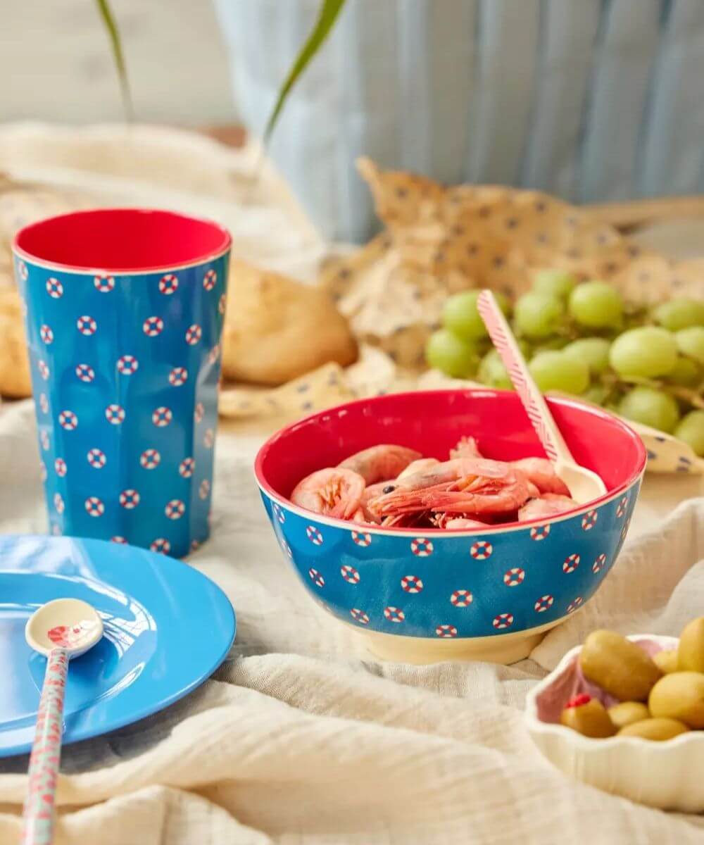Grand Gobelet Bouées Melamine de la marque Rice sur une table ambiance bord de mer présenté avec le bol de la même collection 