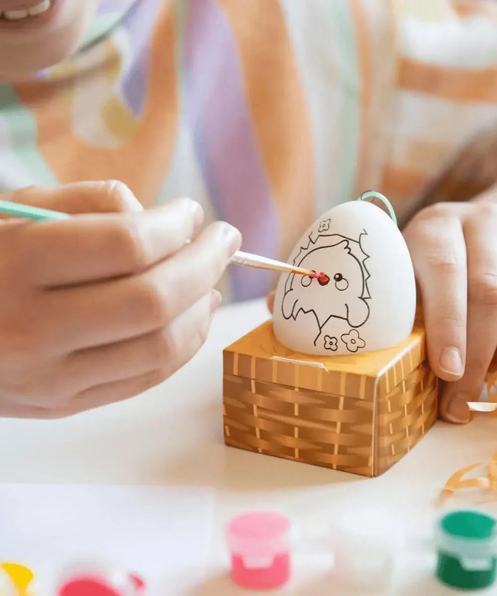 Photo d'un enfant en train de décorer un oeuf de Pâques avec le kit Legami