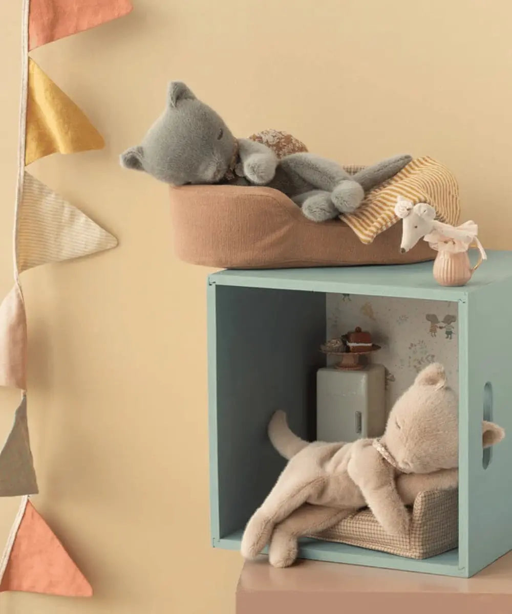Peluche Chaton endormi Crème Pêche de Maileg dans une chambre d'enfant