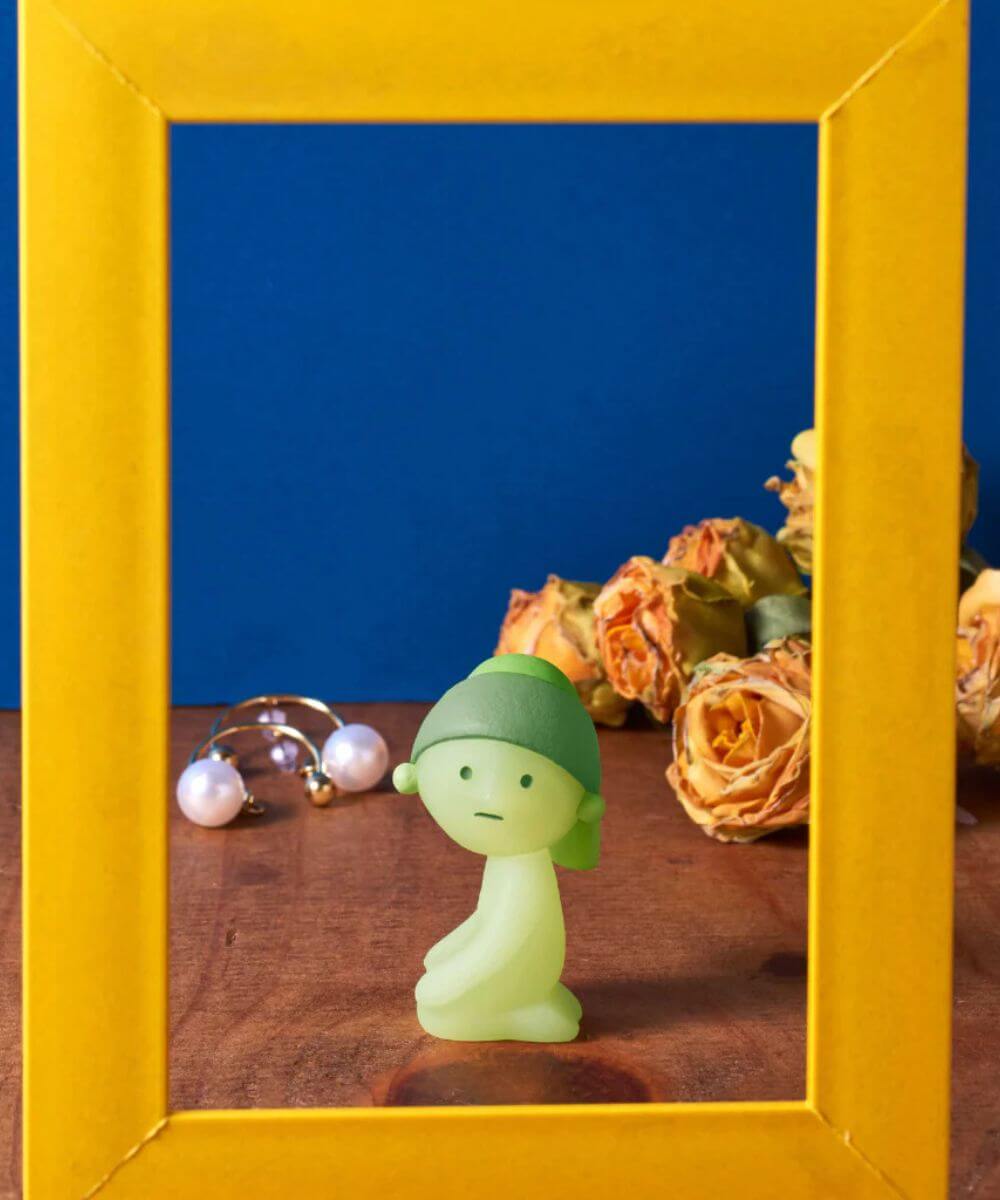 Zoom sur une figurines SMISKI Museum sur une table vu a travers un cadre jaune