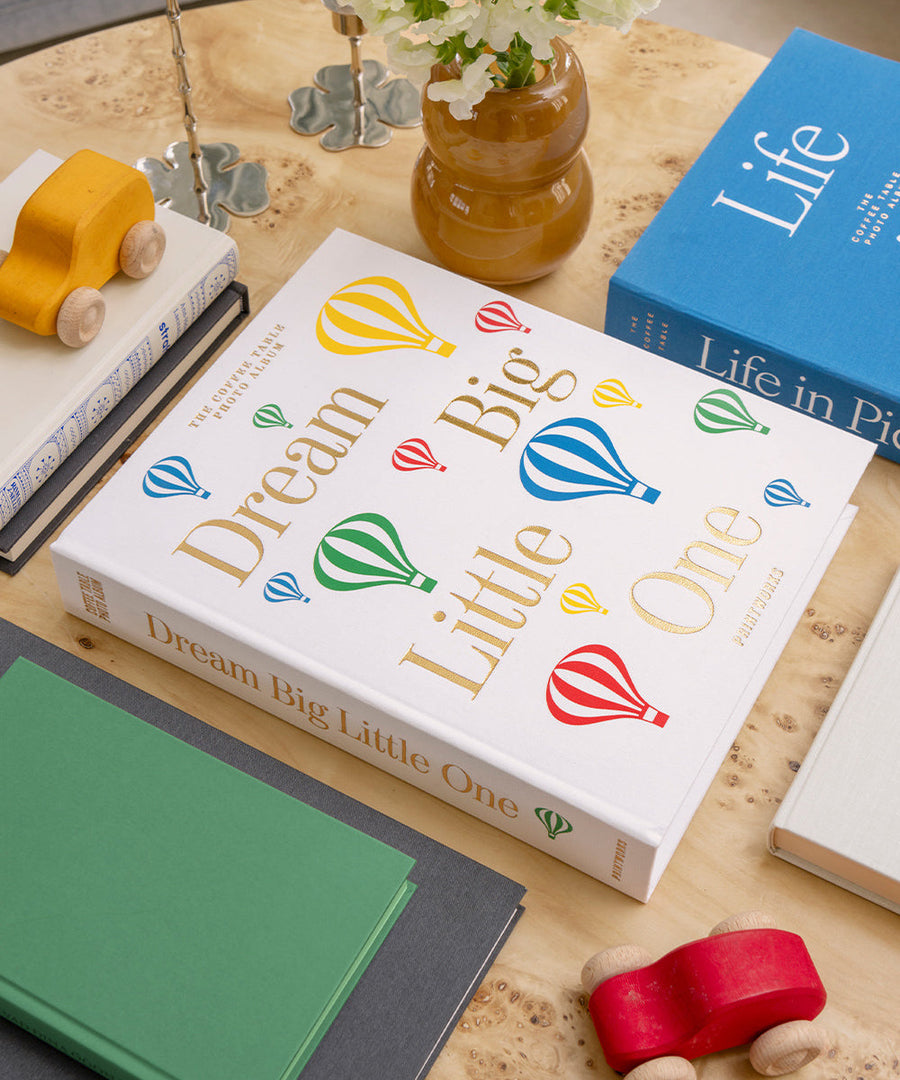 Album photo Printworks Dream Big Little One sur une table avec des jouets