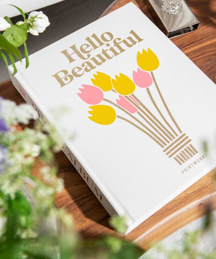 Couverture à tulipes de l’album Hello Beautiful présentée parmi des fleurs