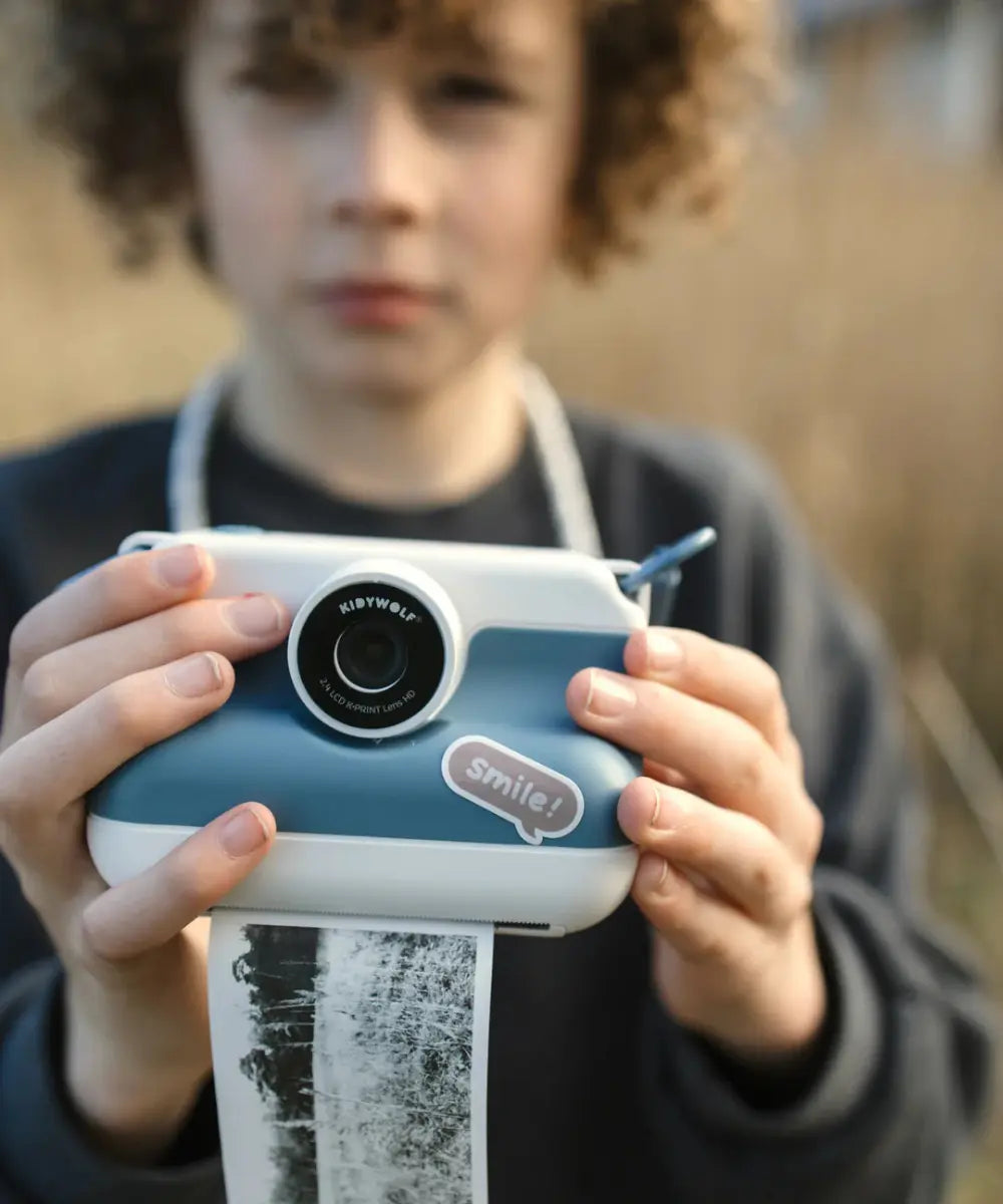 Appareil photo instantané pour enfant K-Print bleu de Kidywolf avec écran couleur arrière et fente d'impression.