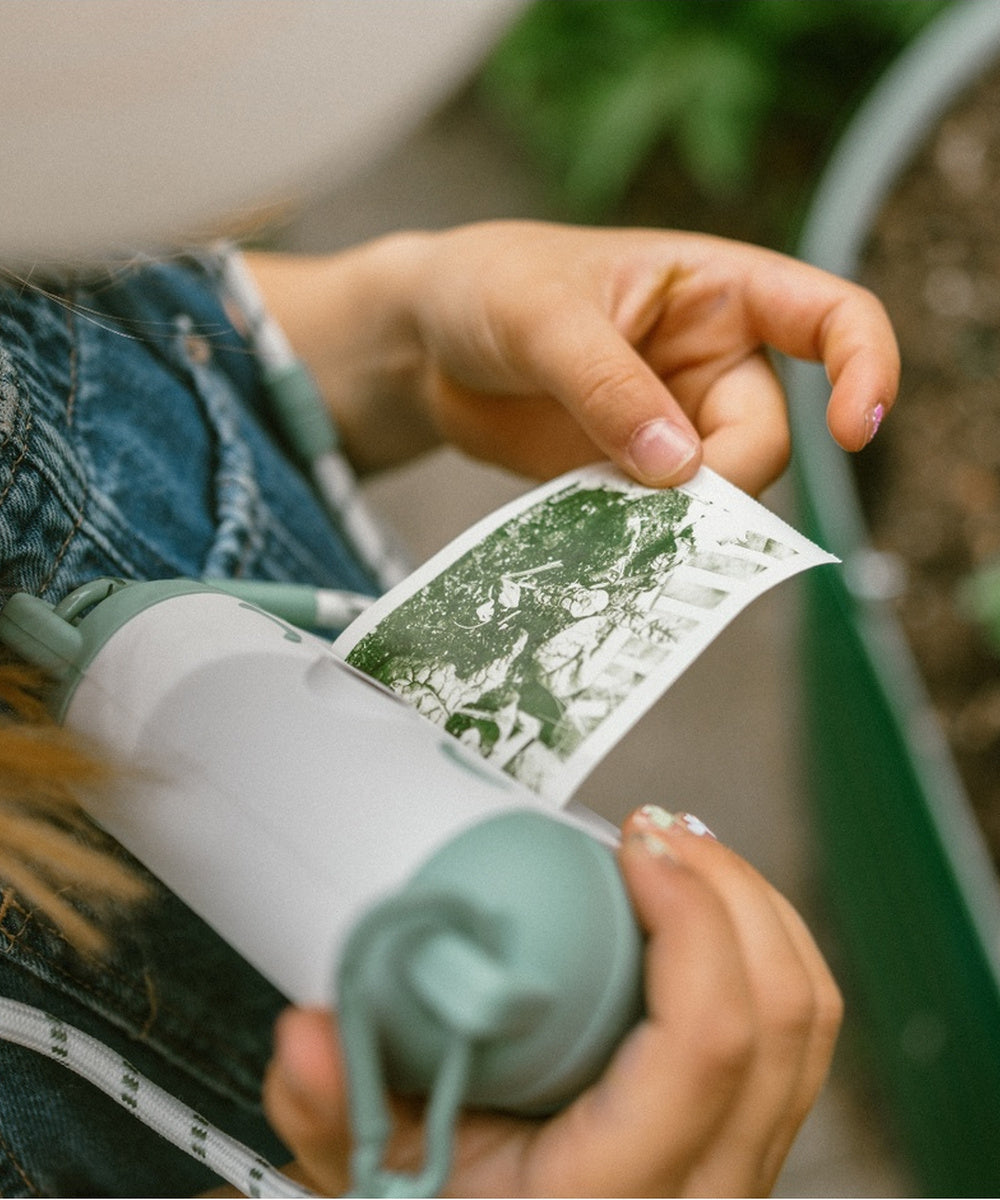Enfant regardant une photo sortie du Kidyprint vert