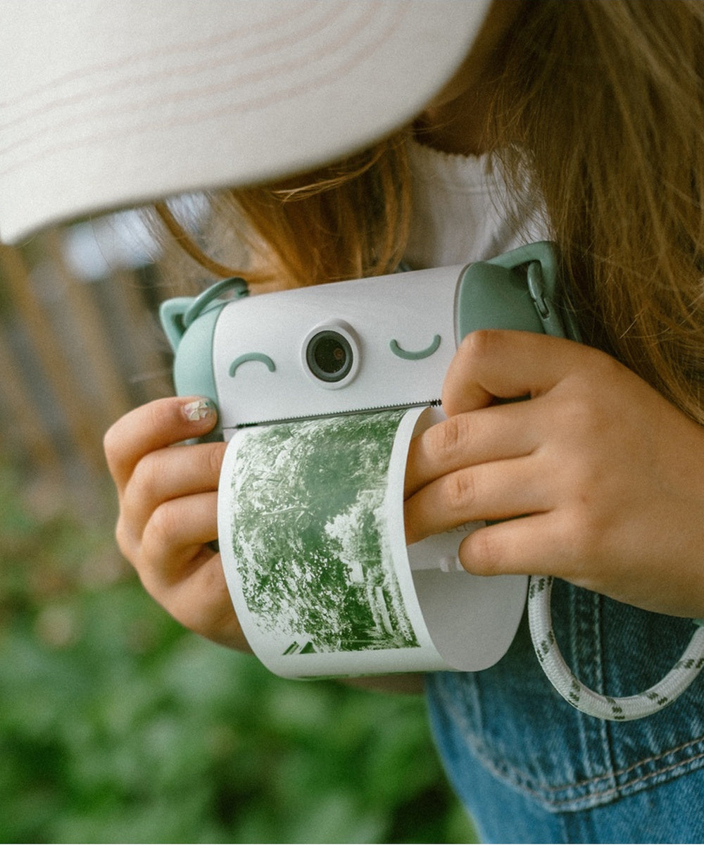 Enfant tenant le Kidyprint vert avec sa photo imprimée
