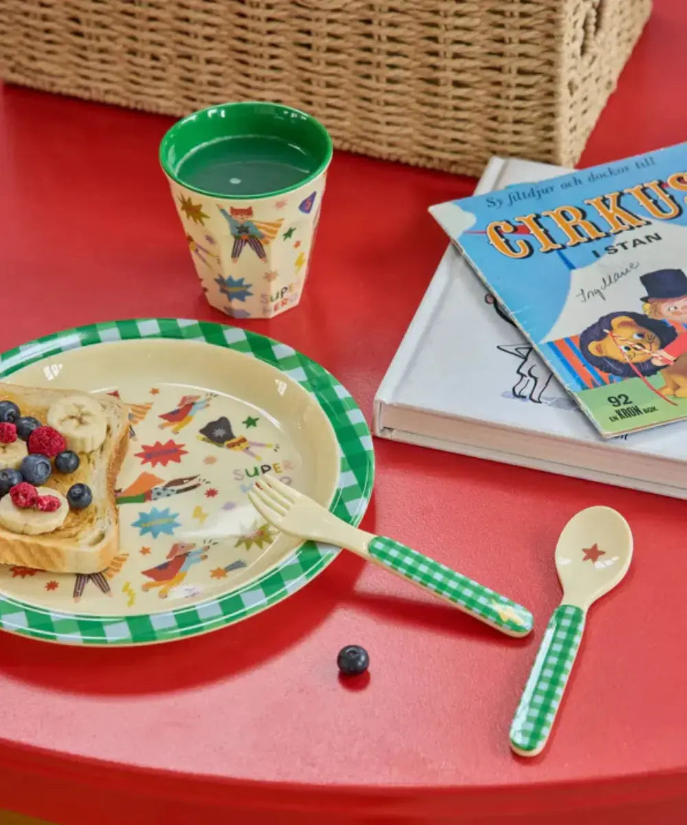 Assiette en melamine Hero Vert posée sur une table colorée