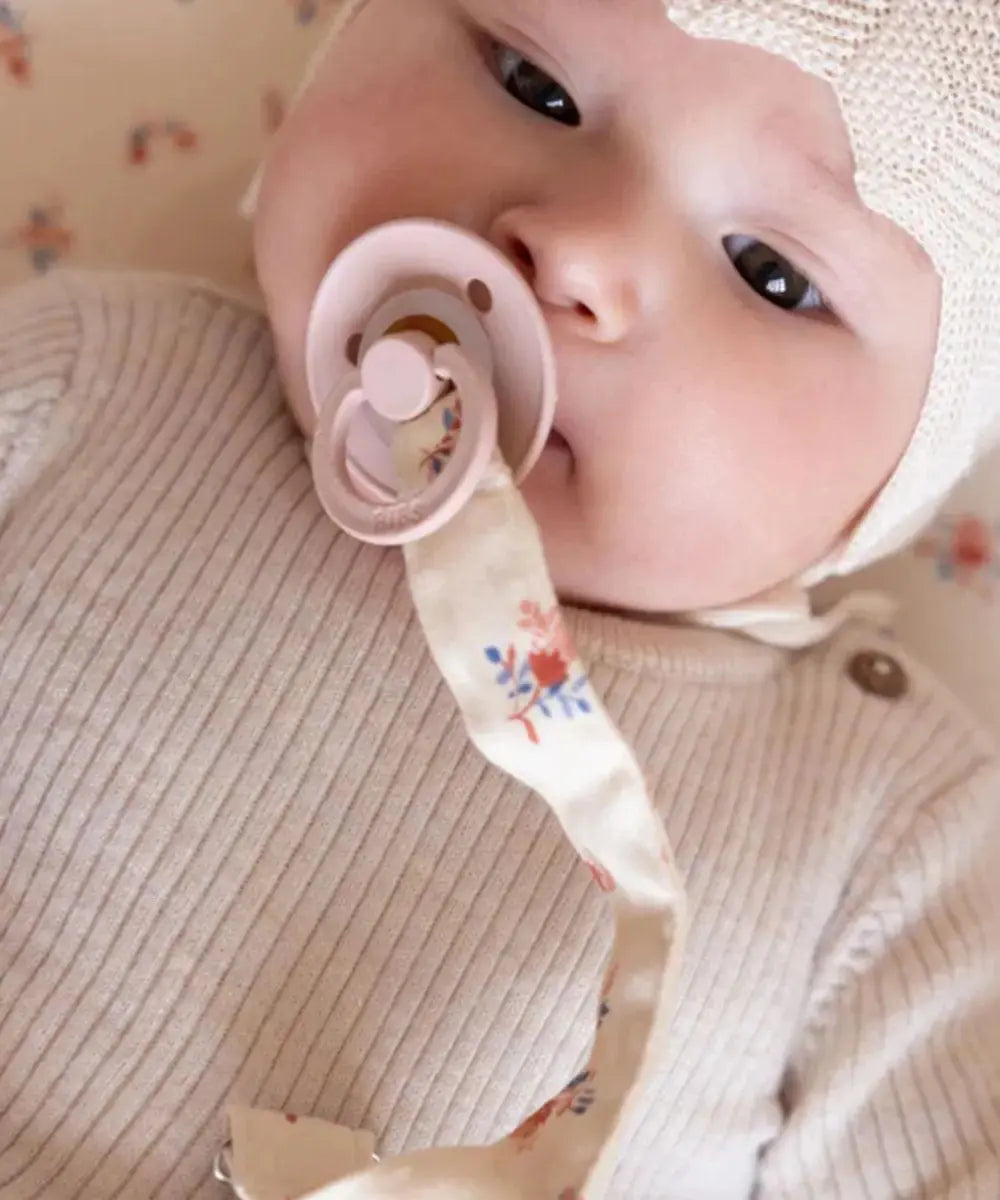 Photo d'un bébé accompagné de l'attache-tétine Berries de Cam Cam Copenhagen