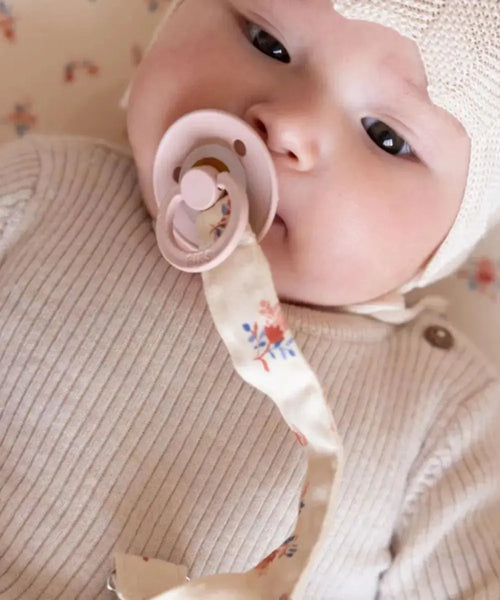 Photo d'un bébé accompagné de l'attache-tétine Berries de Cam Cam Copenhagen