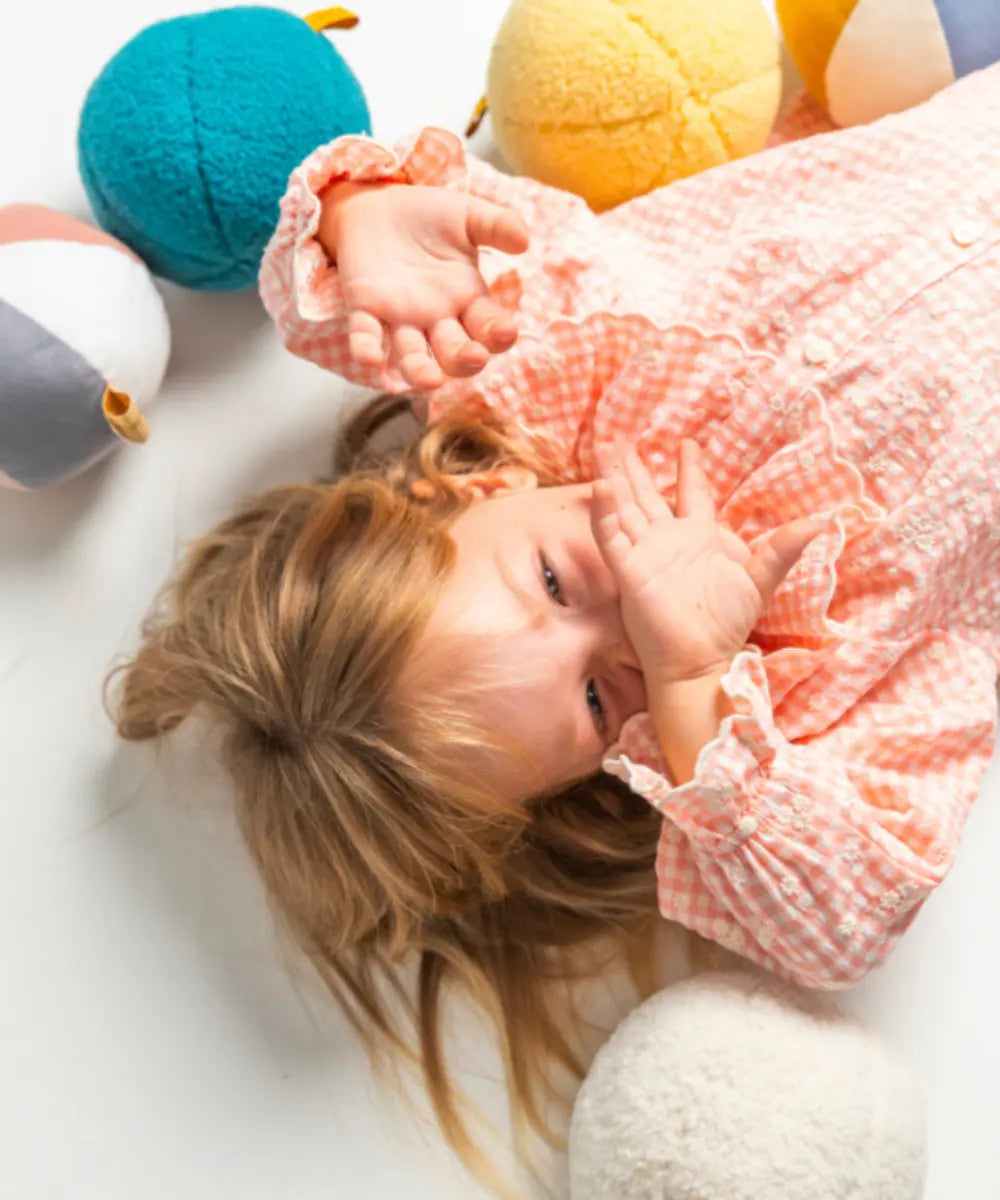 Petite fille jouant avec le Ballon peluche Ourson jaune de la marque Ratatam