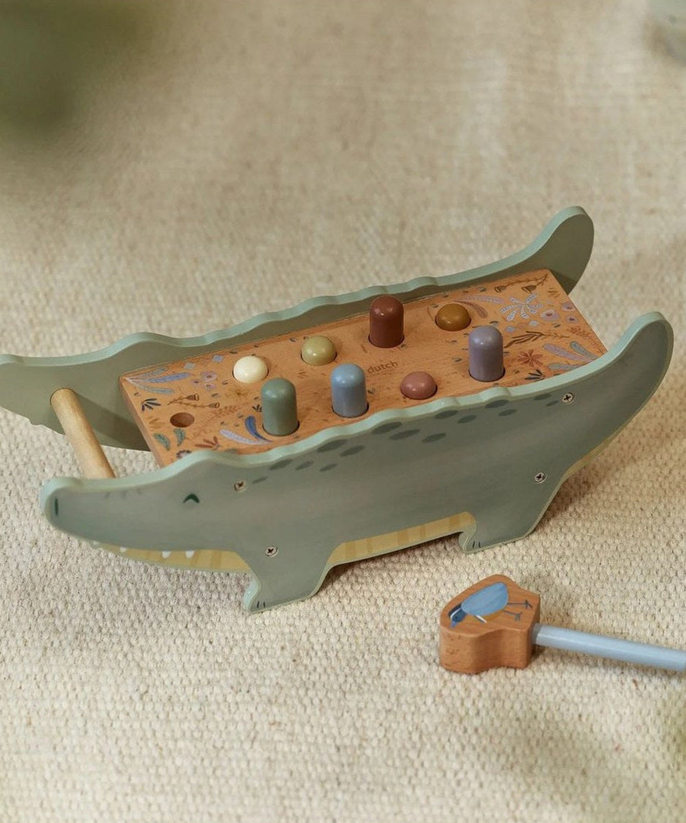 Banc à marteler crocodile et marteau-oiseau sur fond beige