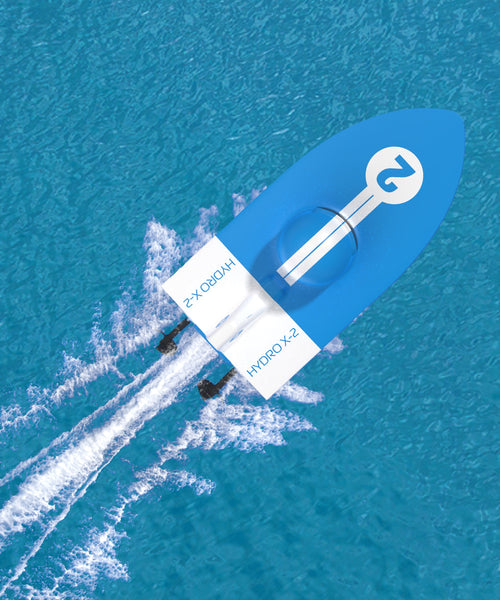 Bateau Hydro Racer bleu et blanc de Sharper Image vu du dessus en déplacement sur l’eau