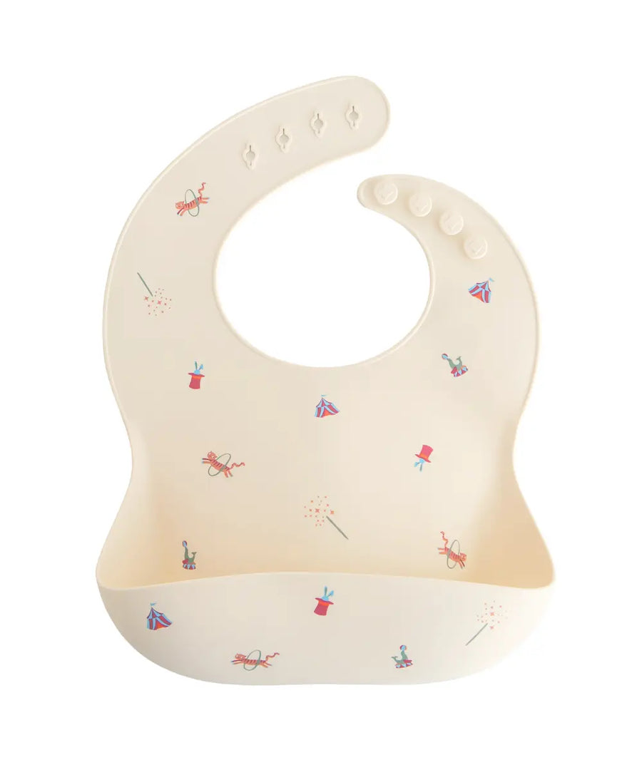 Bavoir en silicone Circus de la marque Mushie sur fond blanc
