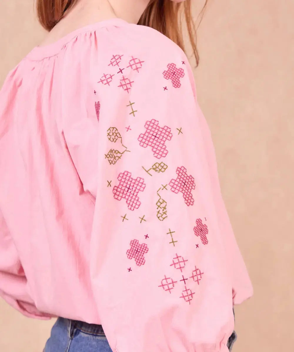 Photo zoomée présentant les broderies des manches de la blouse Spinoza rose