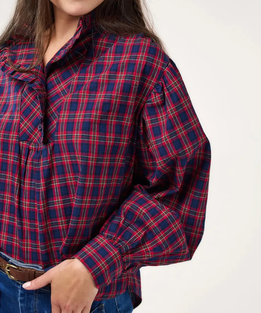 Blouse ample en coton tartan rouge et marine celeste avec col montant a volants et manches bouffantes.
