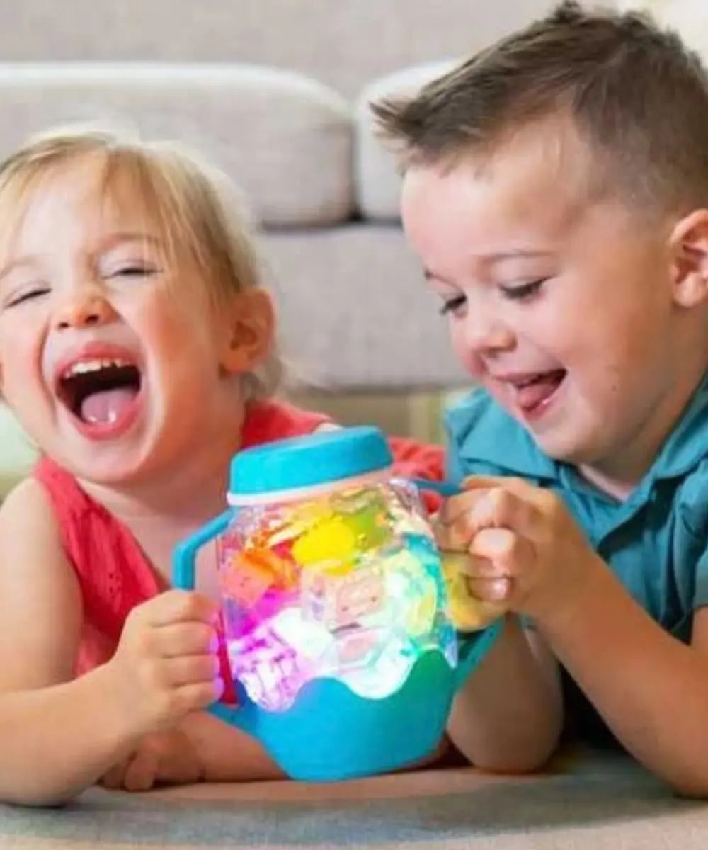 Enfants en train de jouer avec le bocal de jeux sensoriels lumineux de Glo Pals