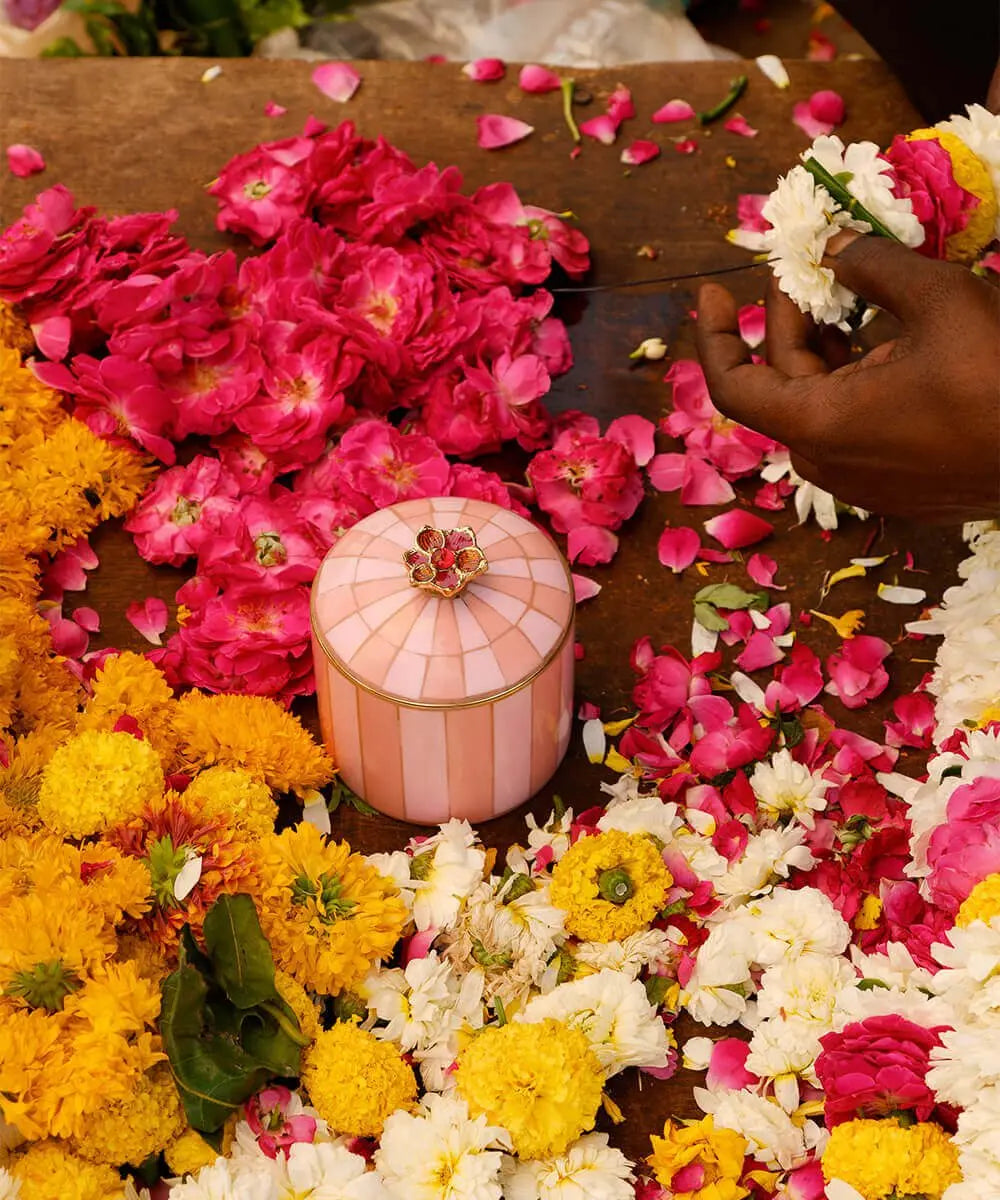 Boîte Cameron Cirque Rose de Doing Goods posée sur une table au milieu de fleurs