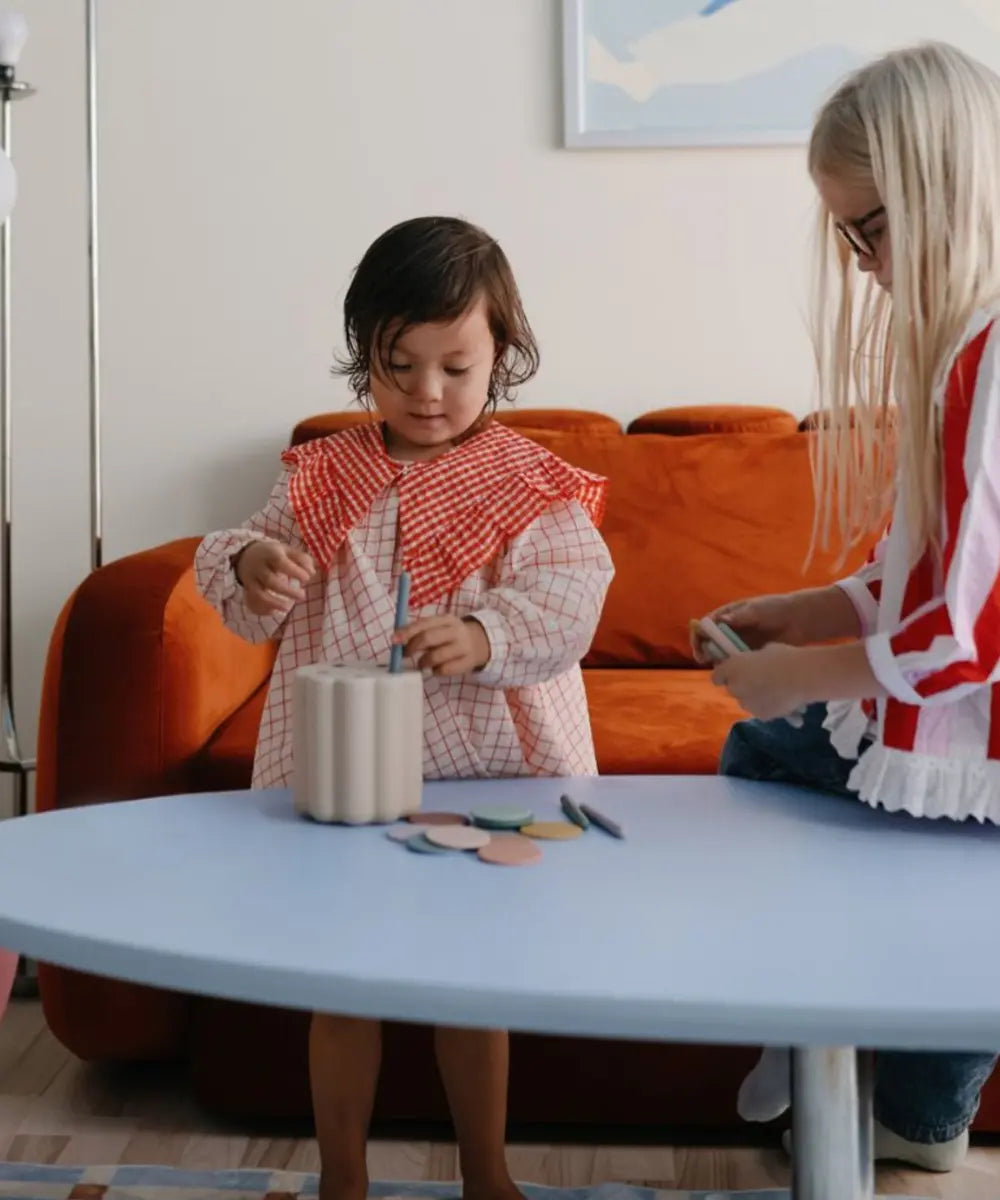 Enfants en train de jouer avec la boîte à formes de Mushie