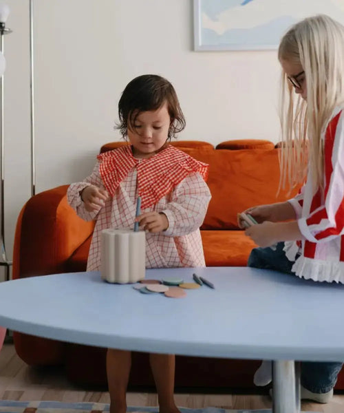 Enfants en train de jouer avec la boîte à formes de Mushie