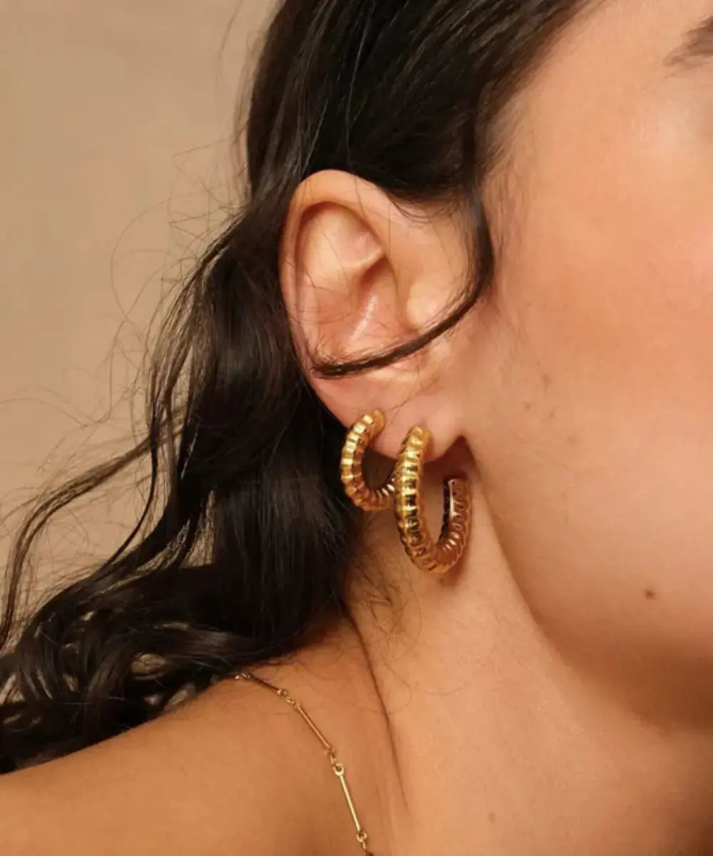 Photo portée des boucles d'oreilles créoles en acier inoxydable Yséane de Bohm Paris