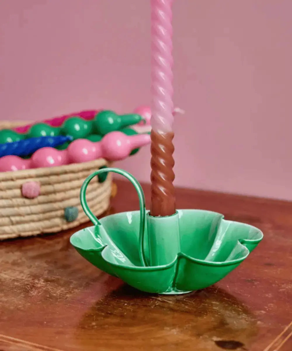 Bougeoir en métal en forme de fleur de la marque Rice posé sur une table en bois.