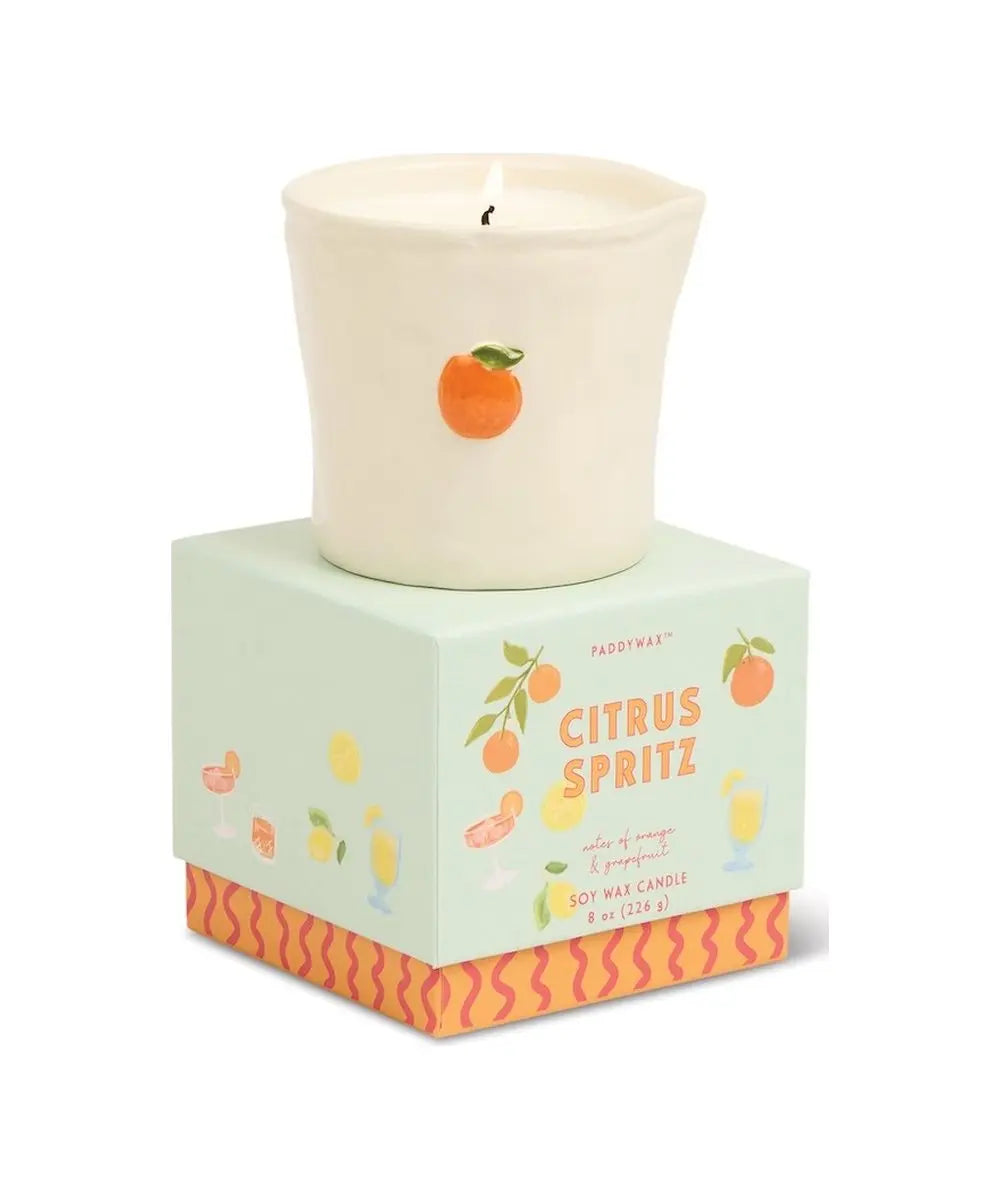 Bougie en céramique Citrus Spritz Bistro de la marque Paddywax vue de face sur fond blanc accompagnée de sa boîte cadeau