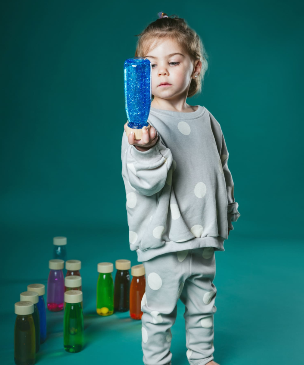 Bouteille sensorielle Float bleue avec paillettes et pompons de Petit Boum