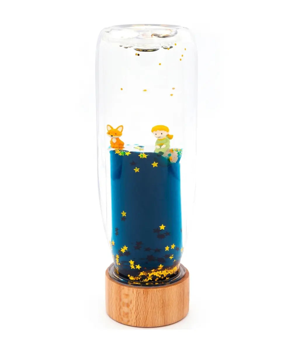 Bouteille sensorielle d'éveil Le Petit Prince avec paillettes et bouchon bois de la marque Petit Boum.