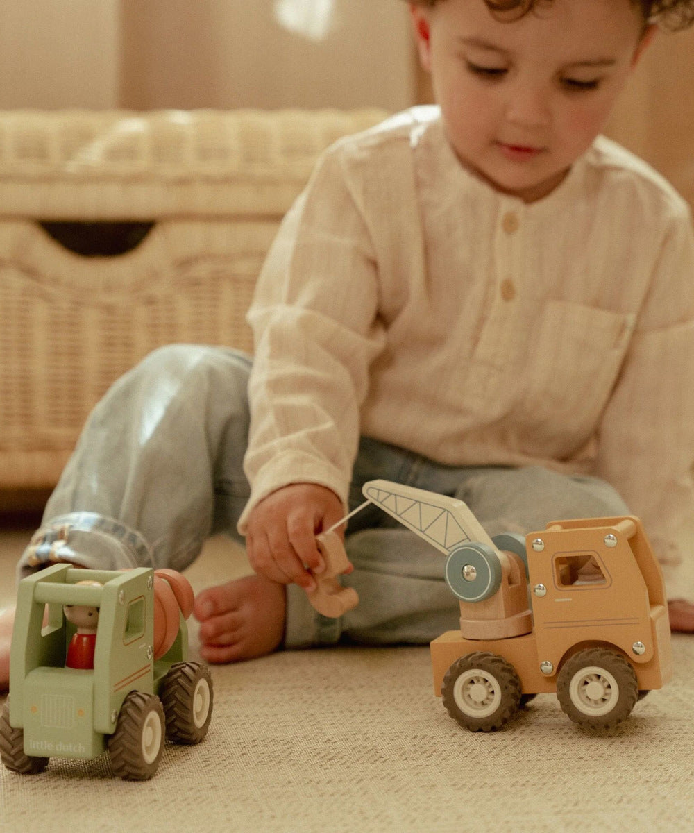 Enfant manipulant le bras du camion-grue en bois Little Dutch