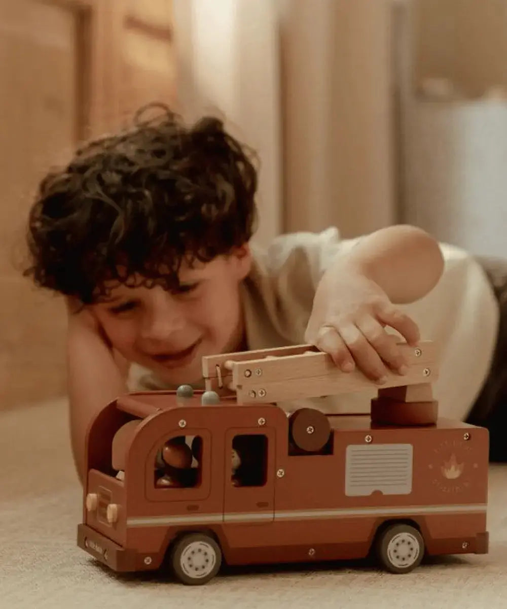 Enfant de deux ans jouant avec le grand camion de pompiers de la marque Little Dutch