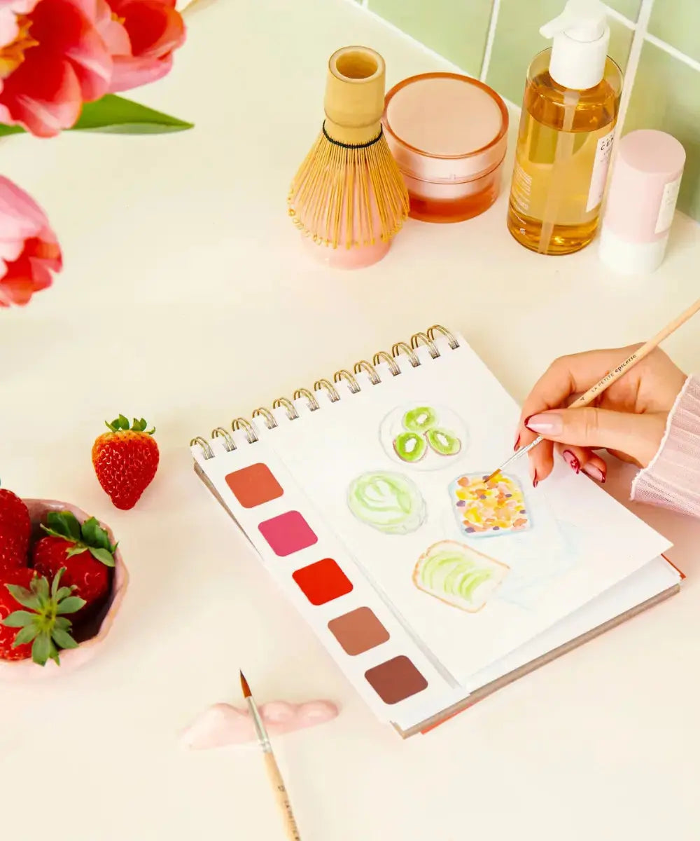 Femme en train d'utiliser le Carnet d'aquarelle Travel Book Self Care de la marque La Petite Epicerie
