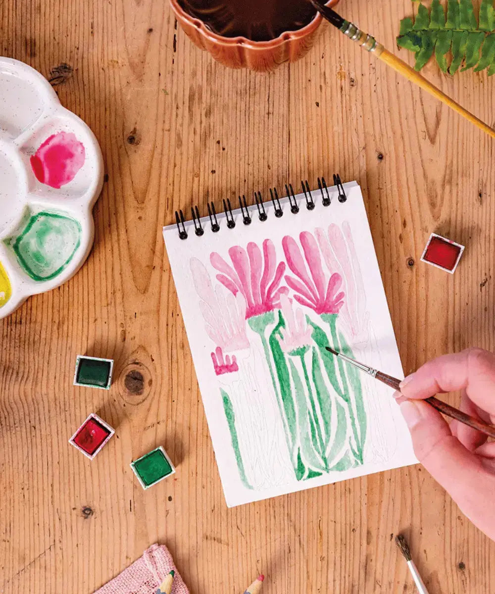 Personne en train de peindre à l'aquarelle une des 14 illustrations Maison Joliette