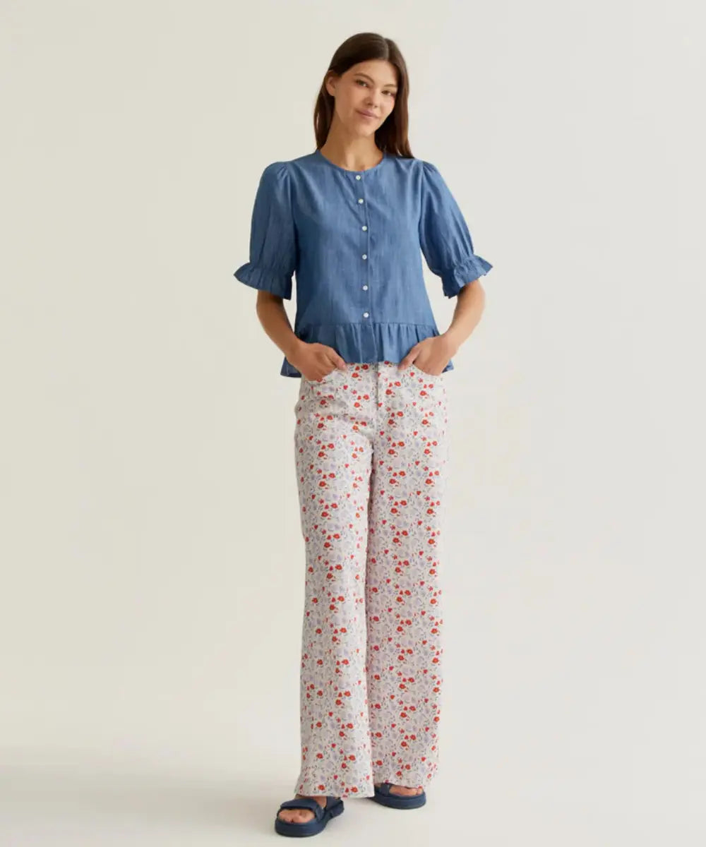Chemise en chambray de coton bleu de Compania Fantastica portée par une femme avec un pantalon fleuri