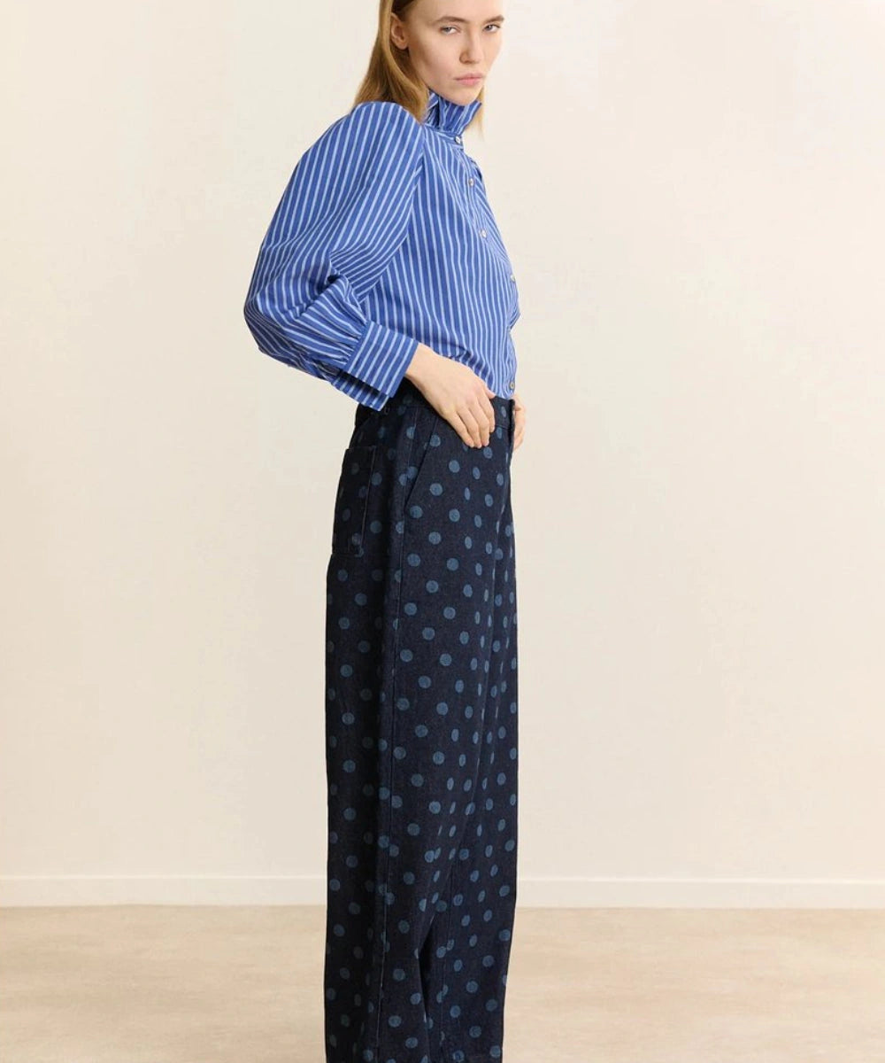 Chemise Derek bleue de Garance Paris portée de profil avec un pantalon à motifs