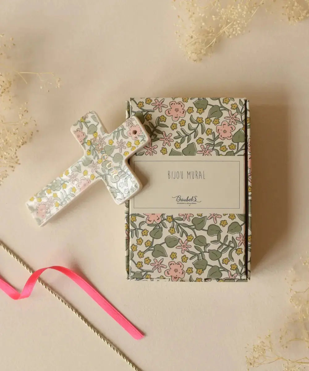 Croix en porcelaine Bonheur motif fleuri Lily de la marque Baubels accompagnée de sa boîte cadeau