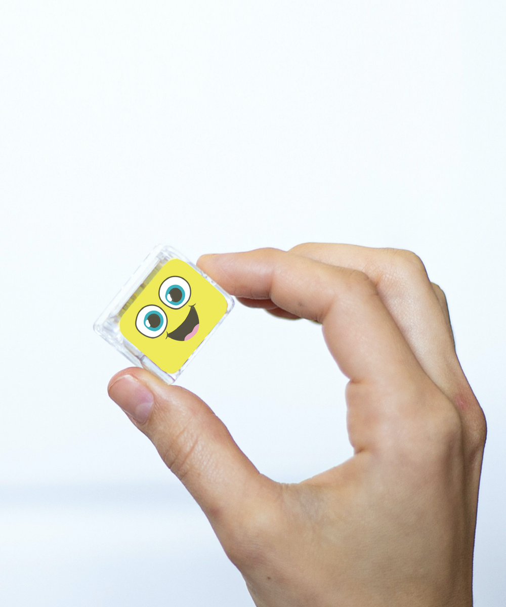 Cube sensoriel lumineux Alex jaune tenu dans une main