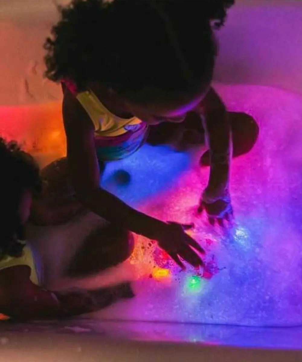 Enfants de 3 ans en train de jouer avec les cubes lumineux de bain Glo Pals
