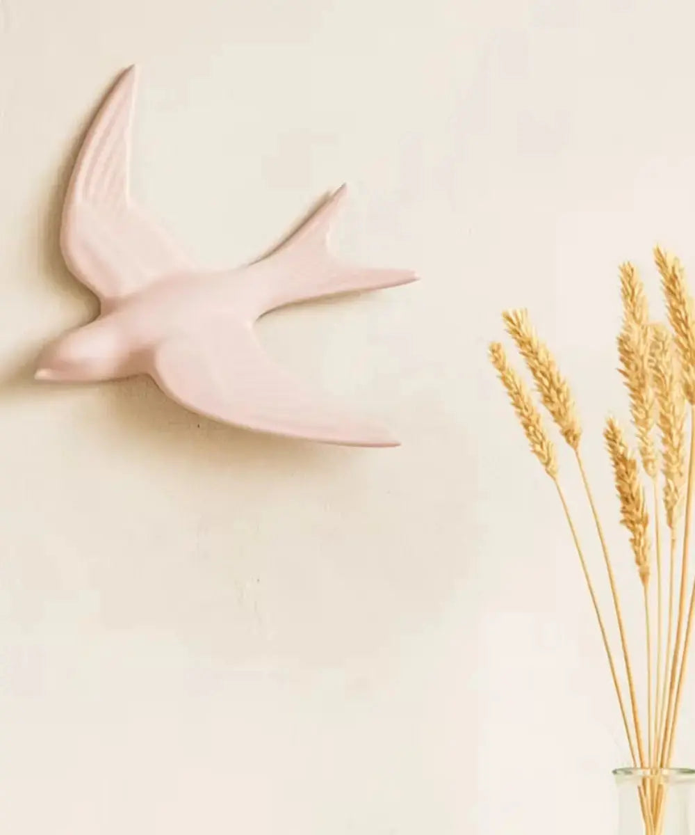 Décoration murale Hirondelle Rose accrochée au mur d'un salon