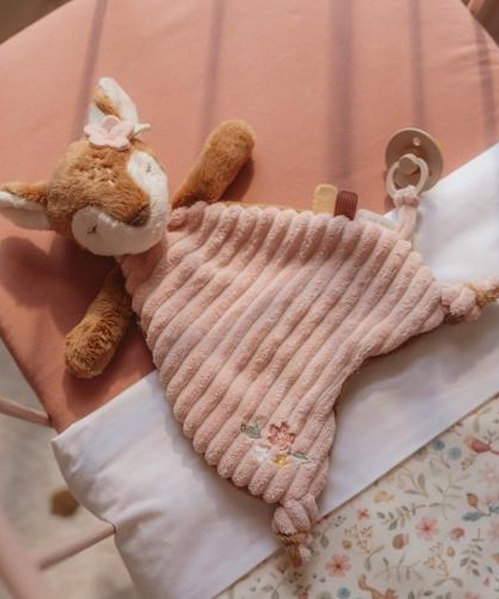 Détail du tissu rose, des étiquettes et de la boucle du doudou faon