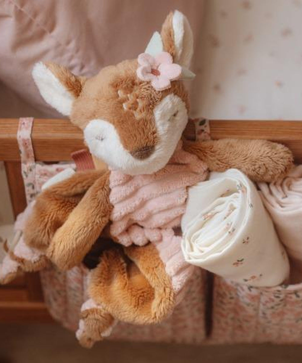 Doudou faon Fairy Garden posé parmi les affaires de bébé