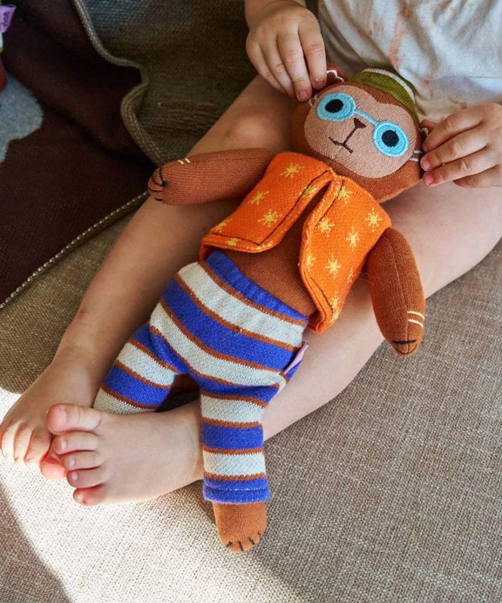 Doudou singe Harry en maille de Rice en situation dans les bras d'un enfant de 2 ans