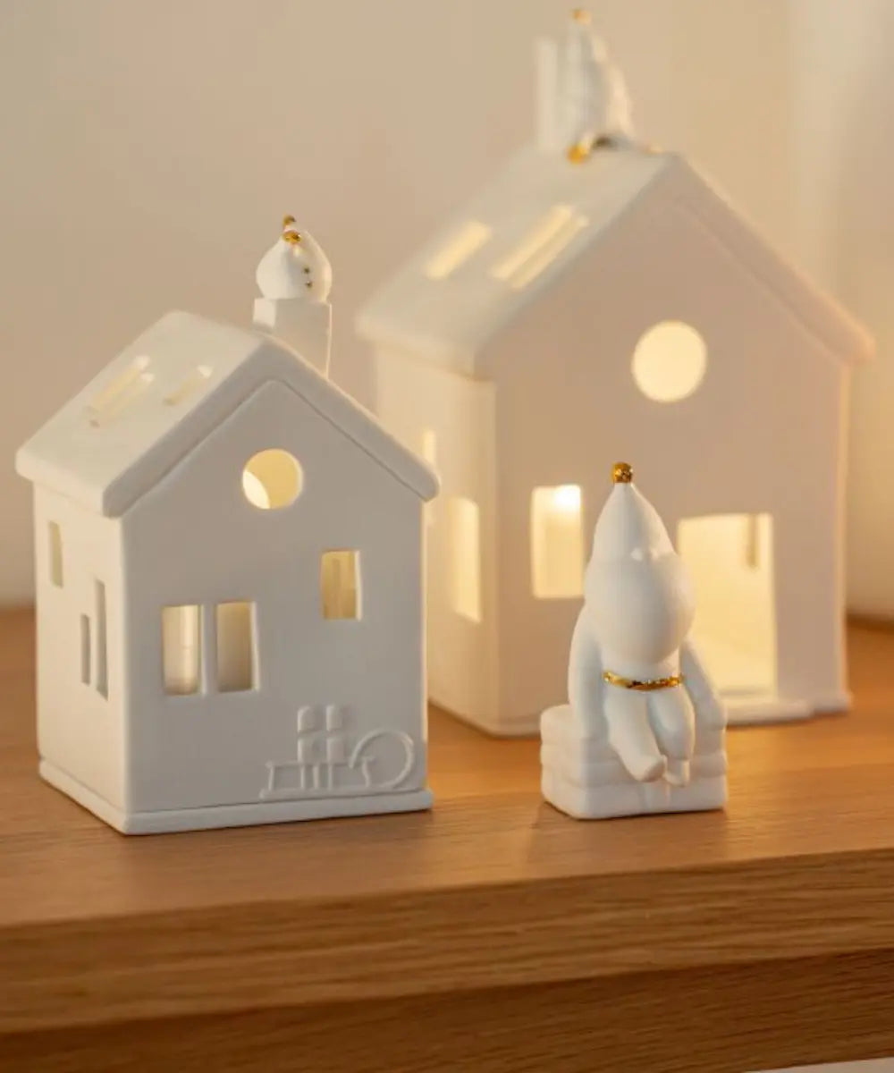 Figurine en porcelaine blanche pere noel assis de la marque rader avec details dores.