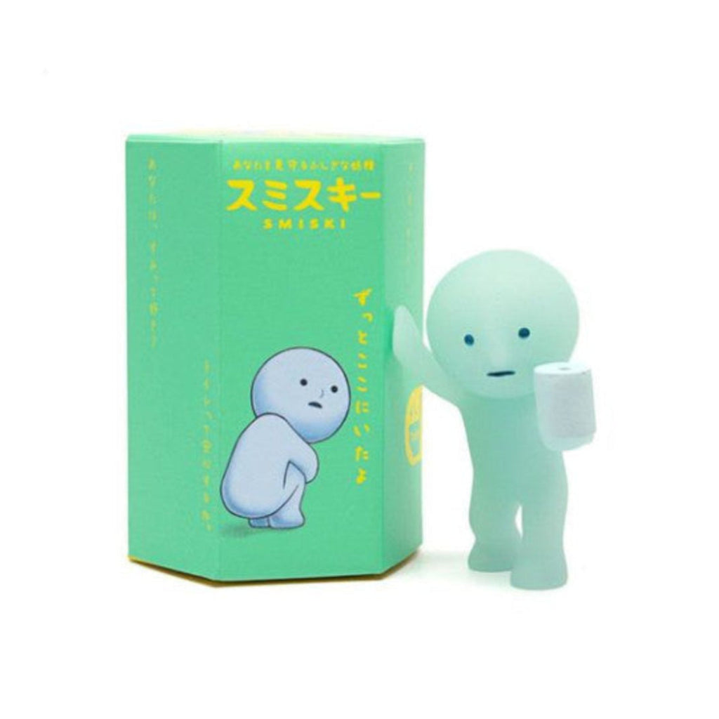 Boîte mystère Smiski série Toilette et figurine phosphorescente tenant un rouleau de papier, sur fond blanc