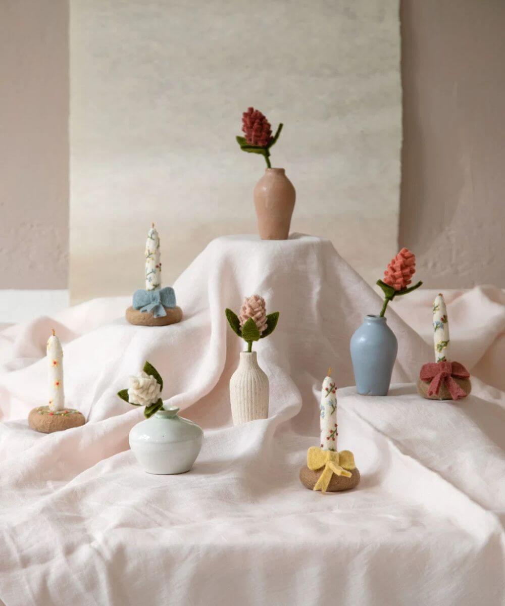 Fleur d'artichaut rouge poudré de la marque Gry & Sif, dans un vase avec d'autres fleurs de la marque