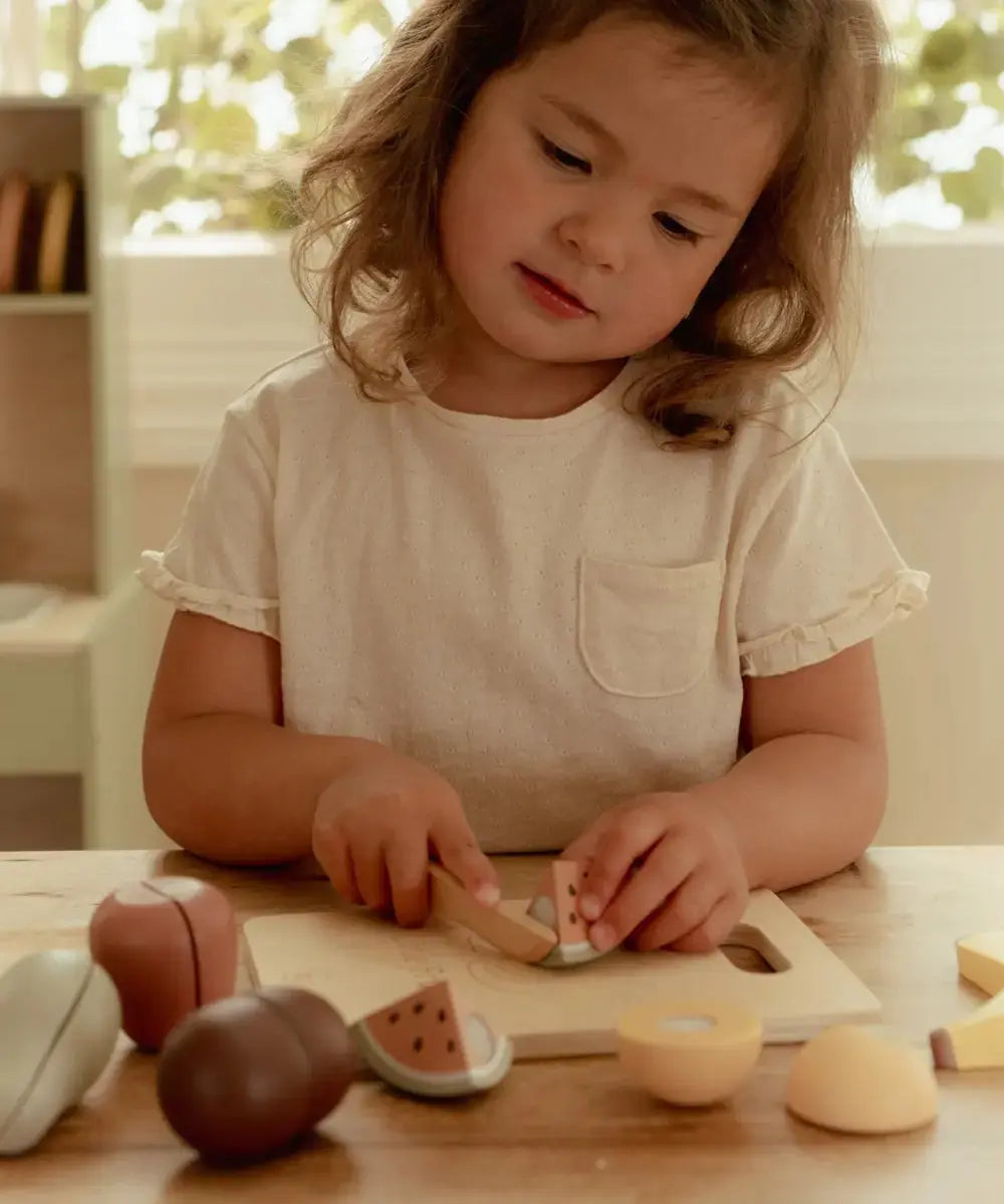 Enfant jouant avec le Set de Fruits en bois à découper de la marque Little Dutch