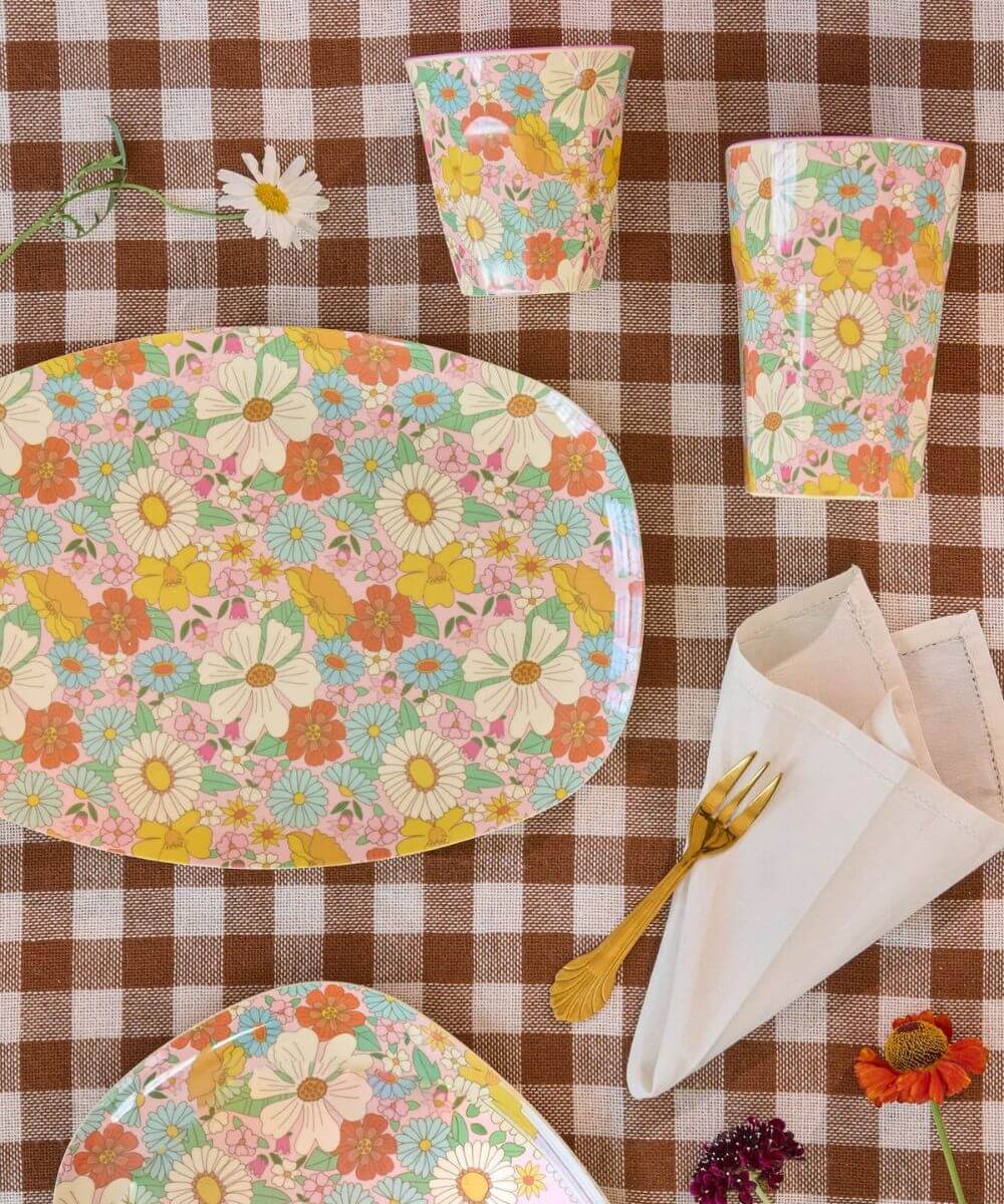 Gobelet médium en mélamine Flower Power de la marque Rice, posé sur une nape avec le grand gobelet et le plateau motif Flower Power