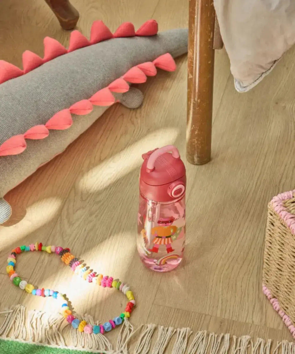 Gourde pour enfant Héros Rose posée sur le sol d'une chambre d'enfant