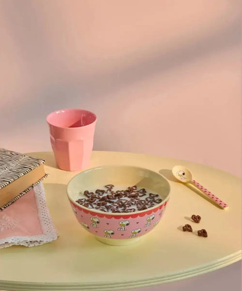 Grand bol en mélamine Rice Snoopy rose posé sur une table avec gobelet rice et cuillère snoopy assortie