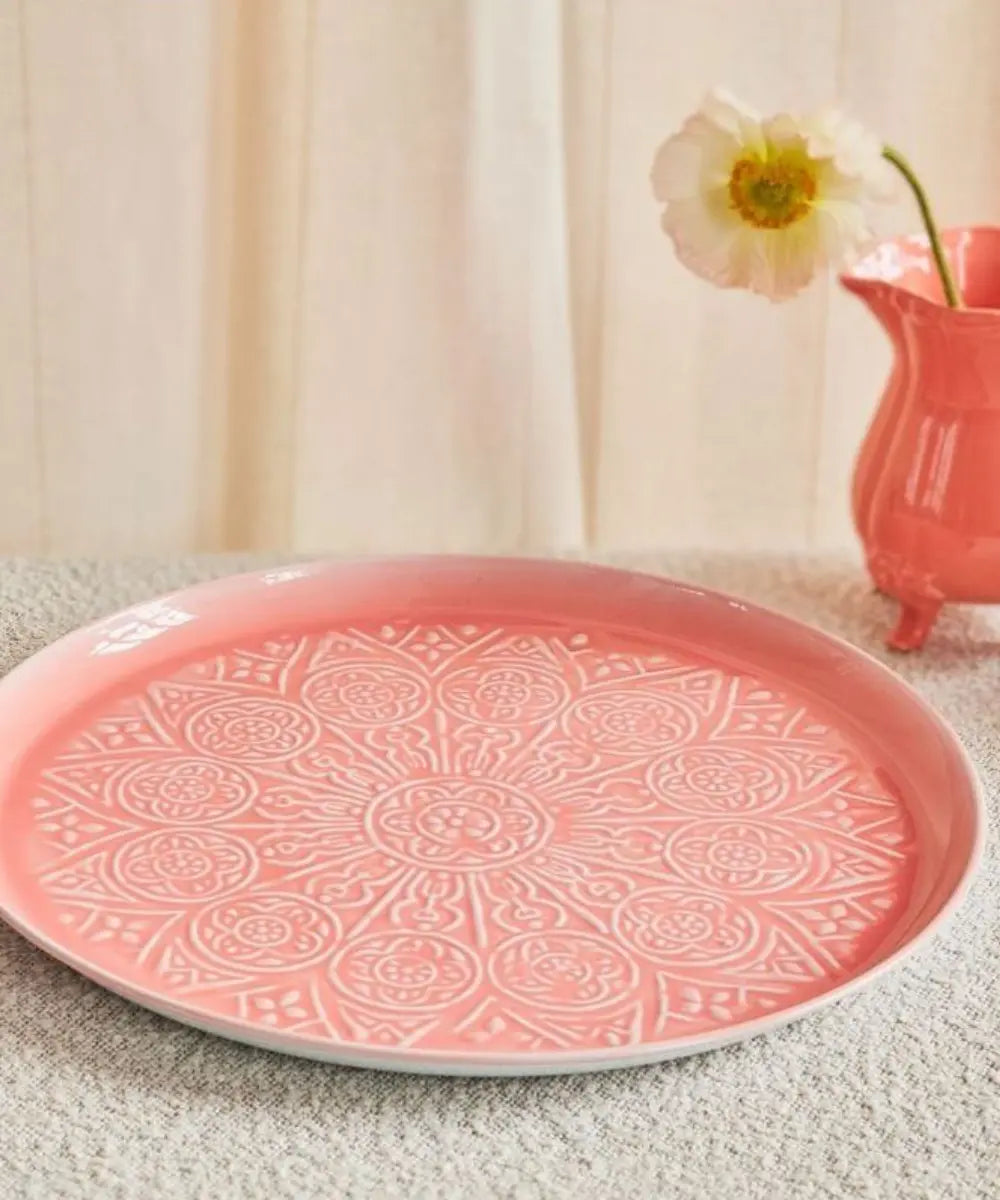 Grand plateau en métal rose de Rice posé sur une table accompagné d'un vase